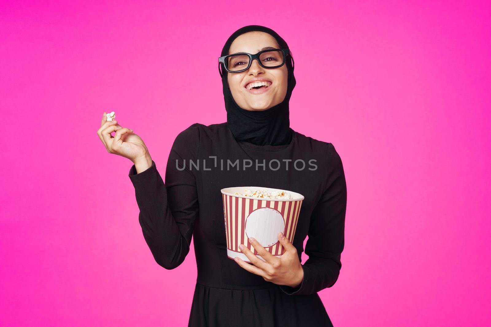 pretty woman in 3D glasses popcorn entertainment movies purple background. High quality photo