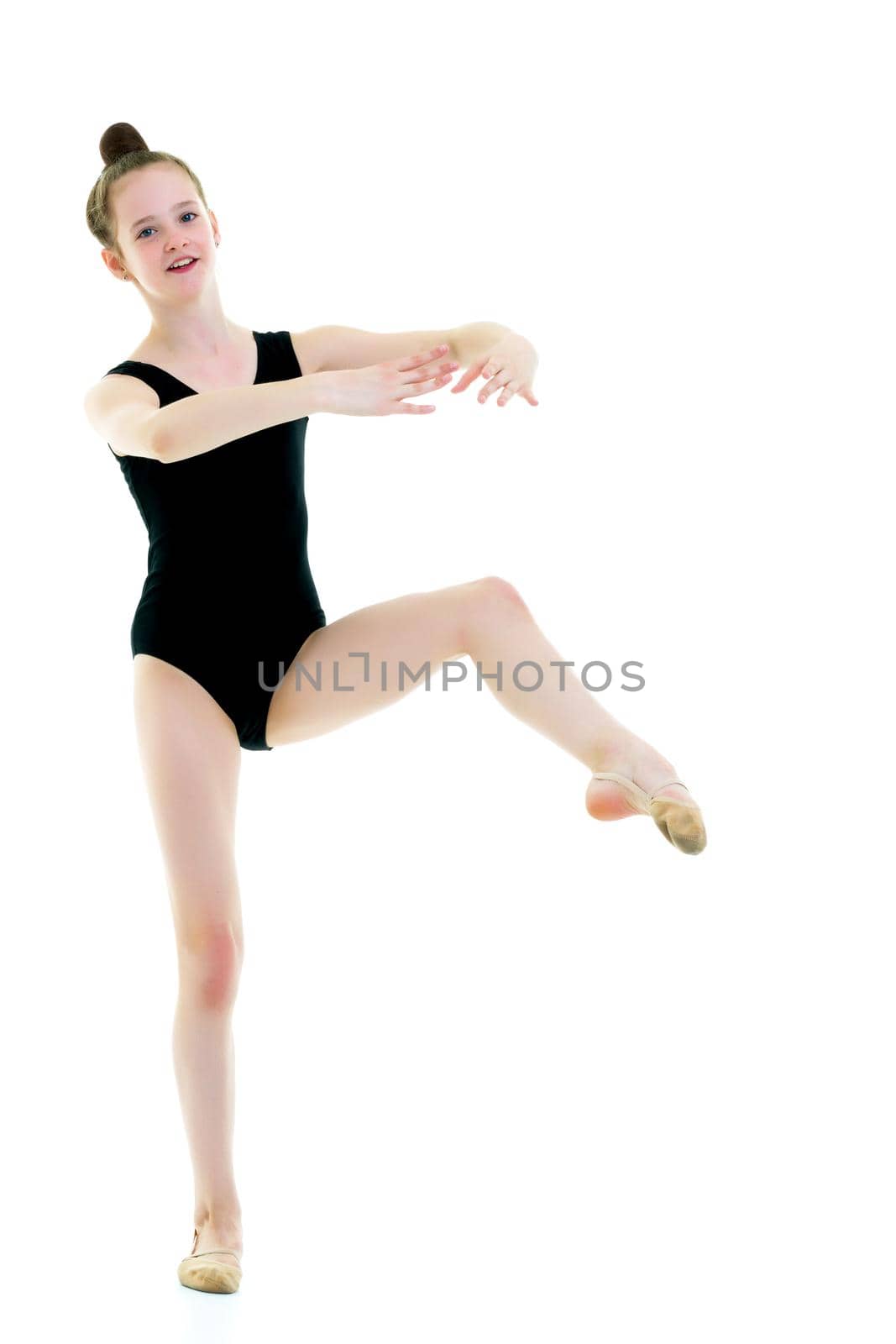 A girl gymnast performs an acrobatic element. The concept of childhood, sport, healthy lifestyle. Isolated on white background.