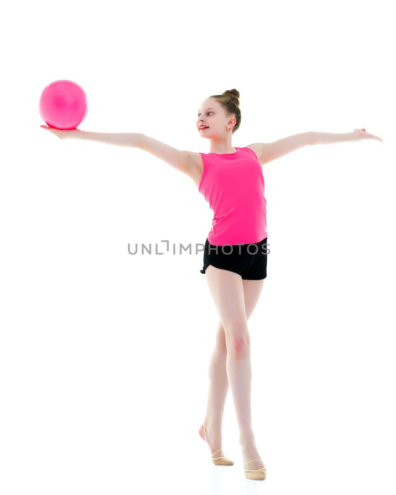 A charming little girl is engaged in fitness with a ball. The concept of gymnastics, health and sports. Isolated on white background.