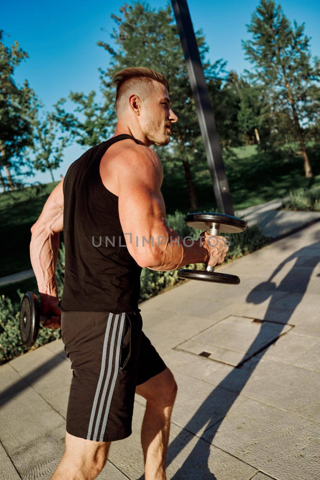 sporty man exercise fitness workout outdoors with dumbbells. High quality photo