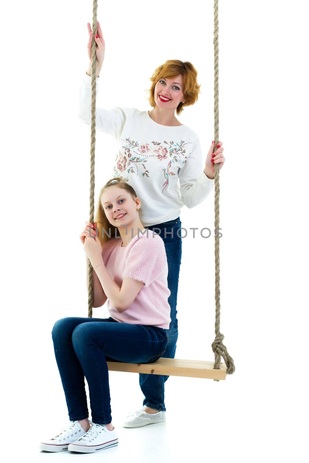 Mom and daughter swinging on a swing. by kolesnikov_studio