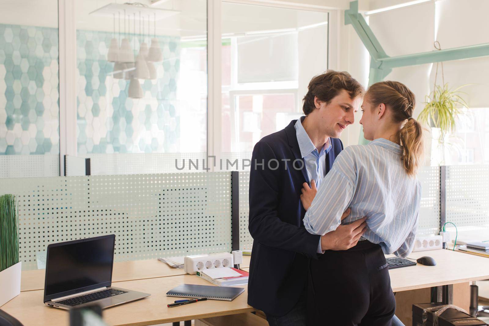 Young colleagues flirting in office by Demkat