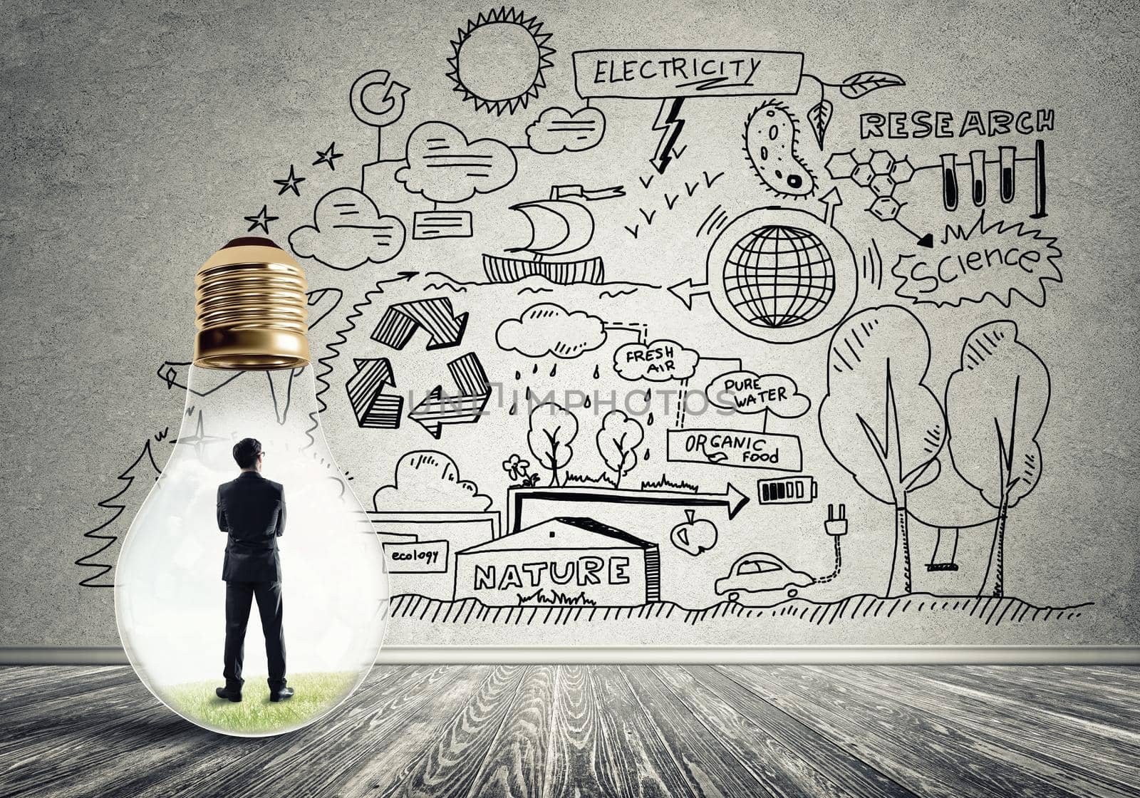 Businessman inside of light bulb in empty concrete room and sketches on wall