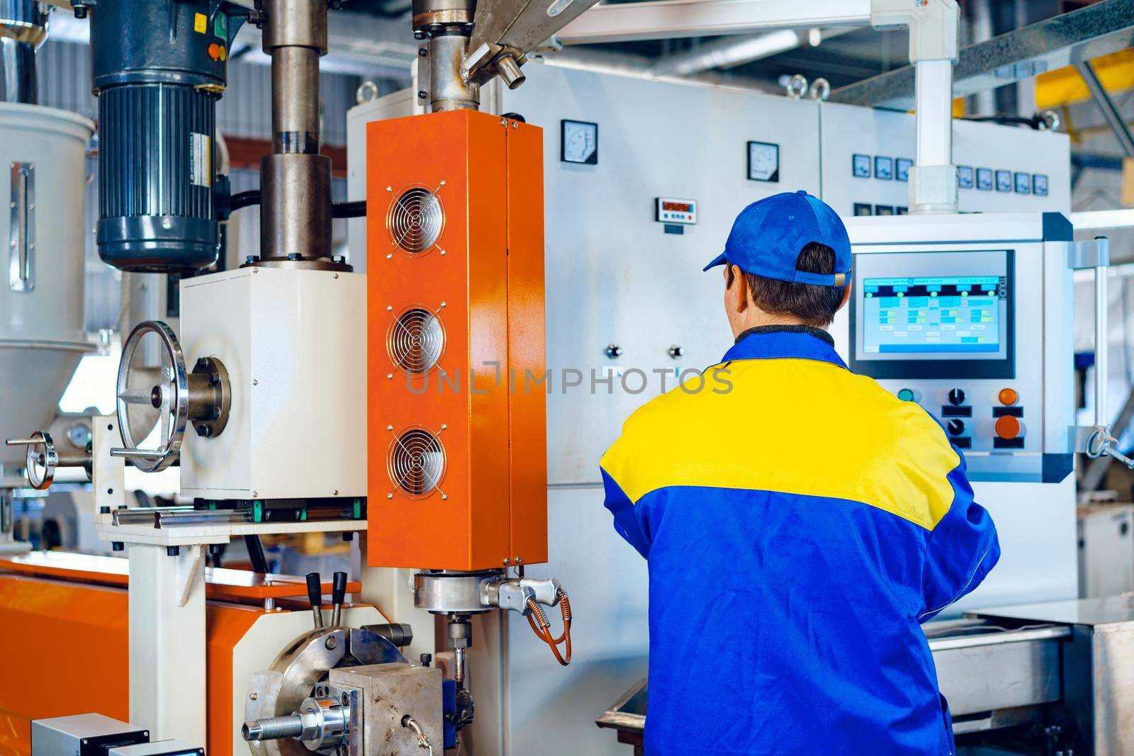 Man worker in manufacturing plant at cable factory machine control computer panel, close up