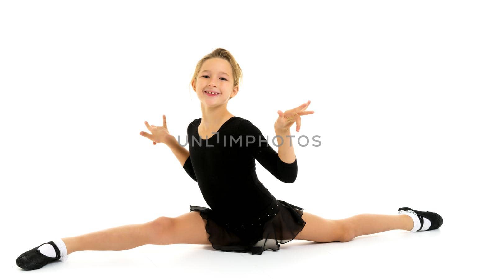 A little girl performs a gymnastic twine. The concept of fitness and sports. Isolated on white background.