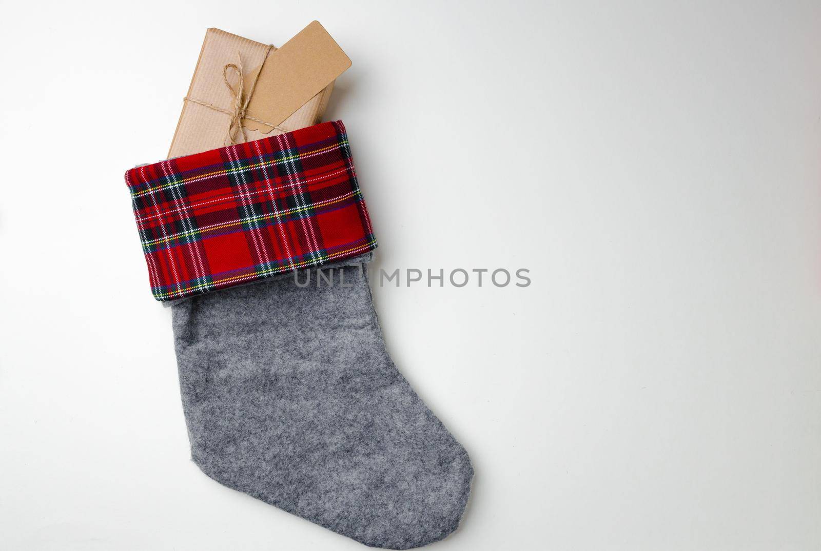 Christmas stocking with wrapped gift on white background top view
