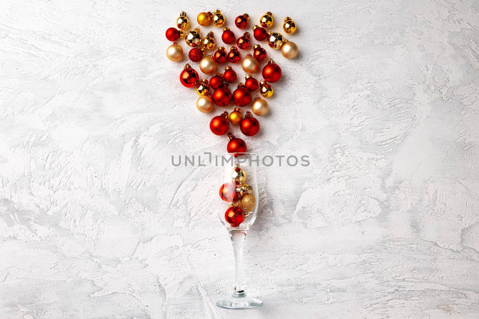 Champagne glass with Christmas balls flat lay top view