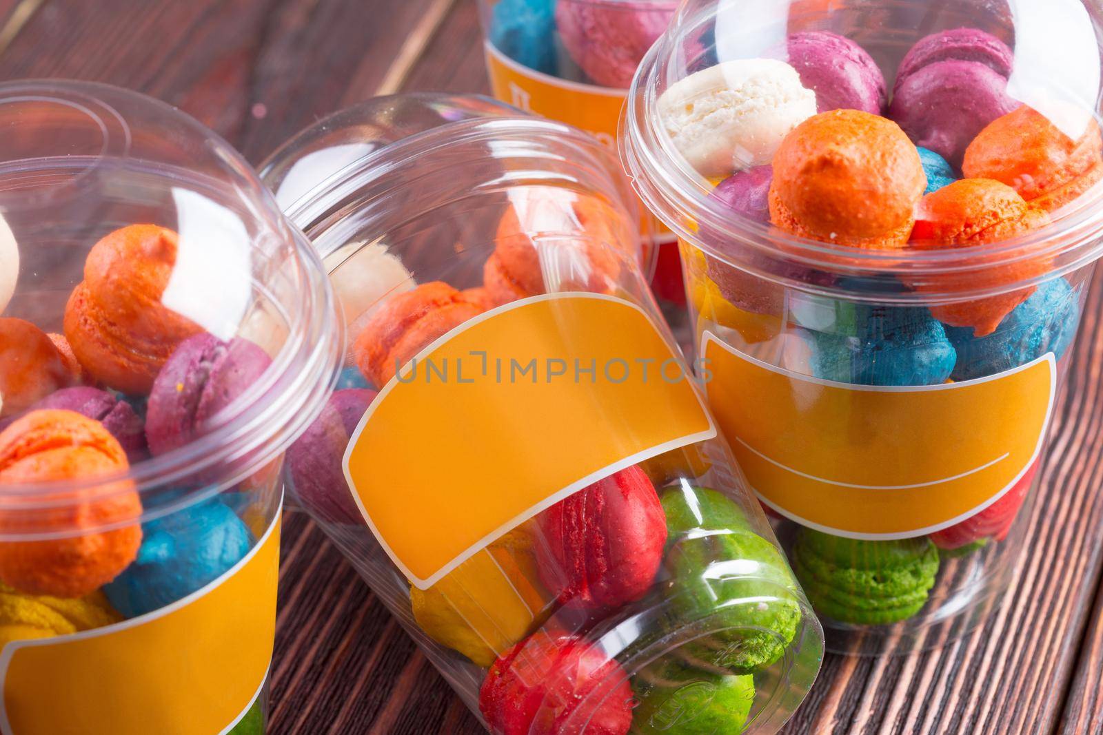 Colorful sweet meringue cookies assortment on wooden table close up