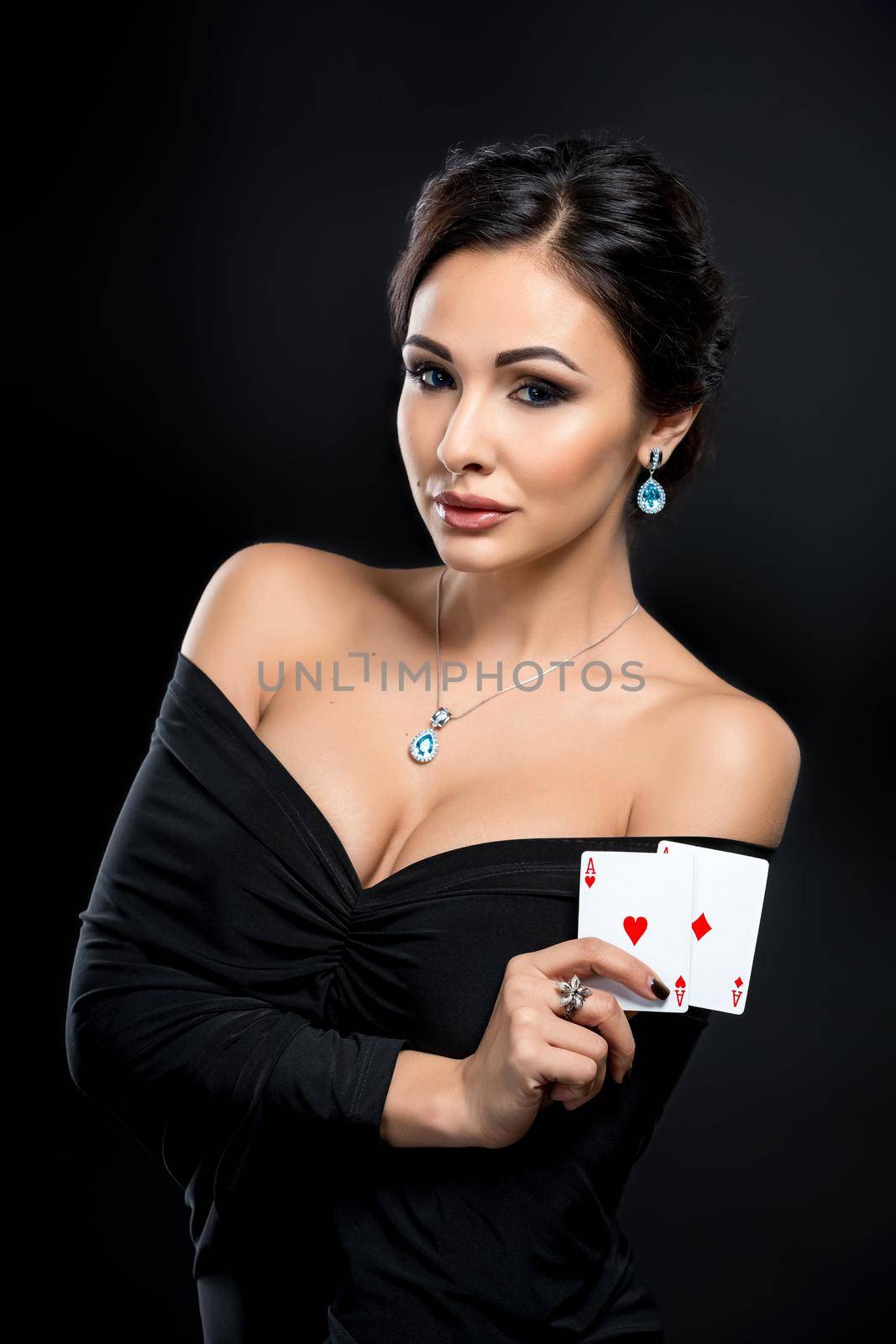 sexy woman with poker cards. Female player in a beautiful black dress