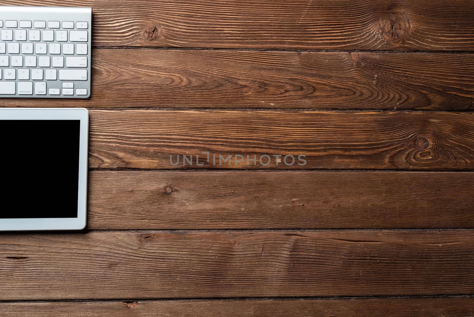 Top view of modern working place. Tablet computer and computer keyboard on vintage wooden surface. Education, creativity and innovation concept with copy space. Digital technology in modern business.