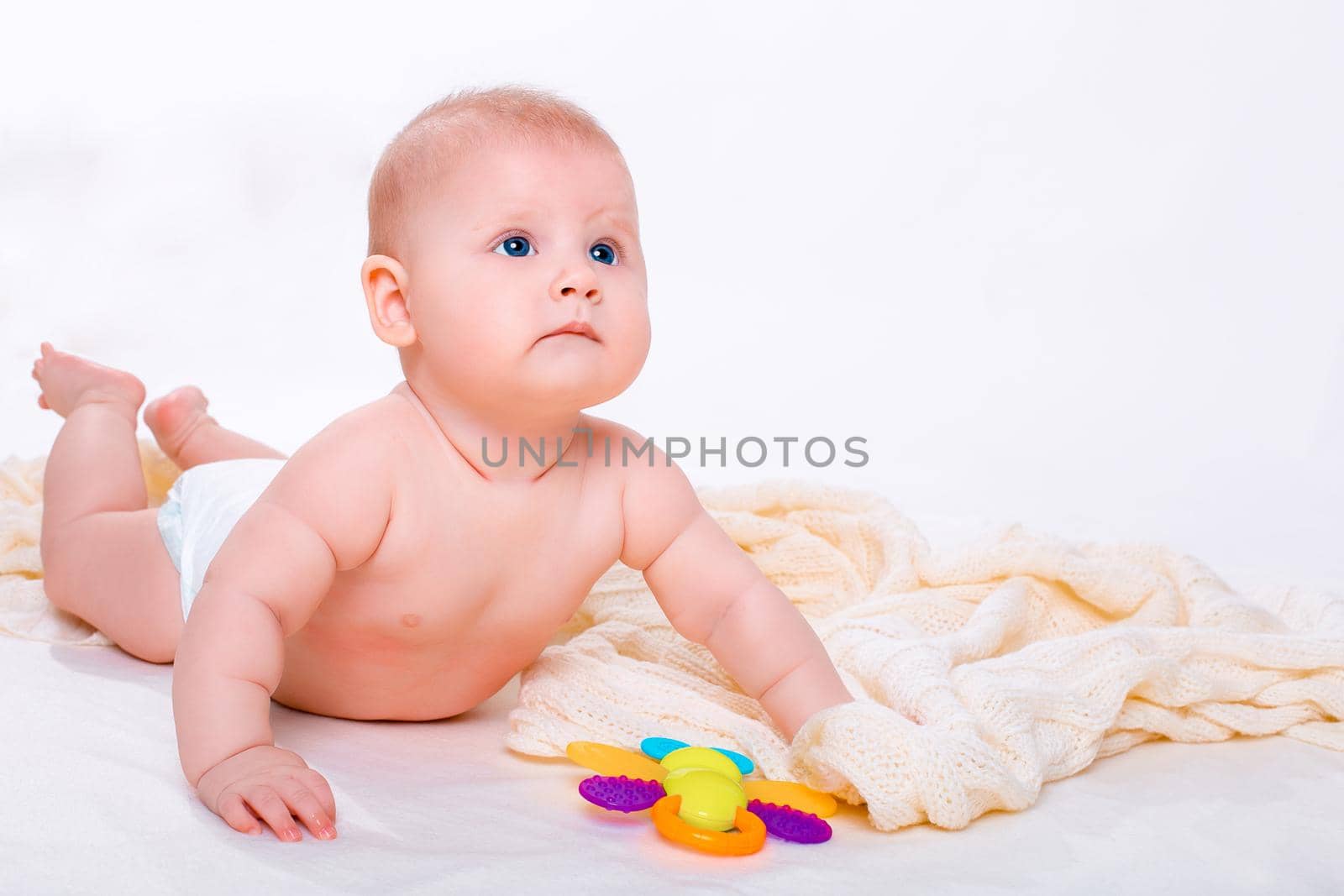 Cute baby girl on white background. Baby in diaper with toy