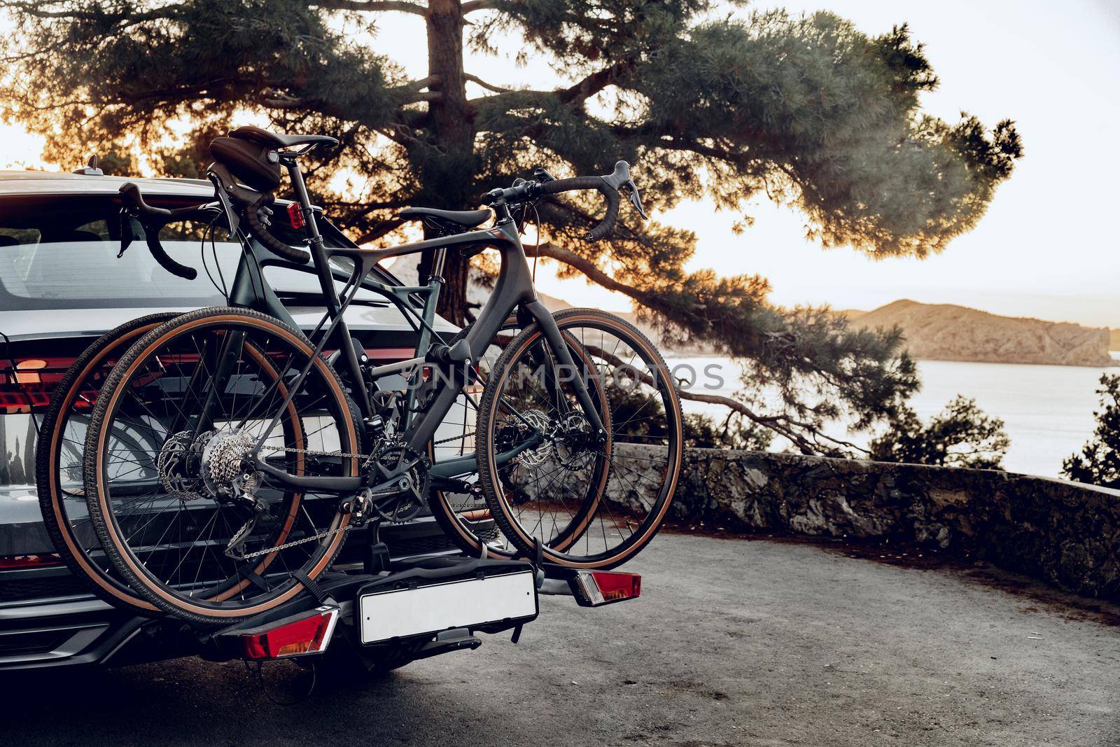 Crossover car with two road bicycles loaded on a rack parked on coastal road