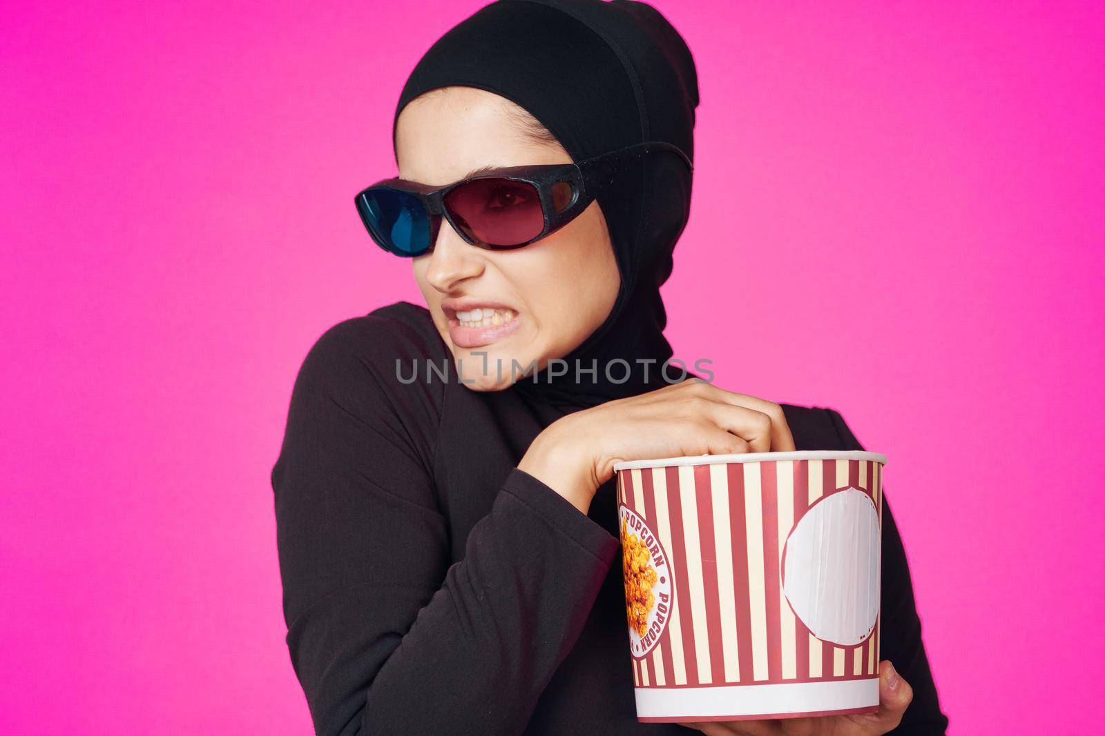 Muslim woman in 3D glasses popcorn entertainment movies isolated background. High quality photo