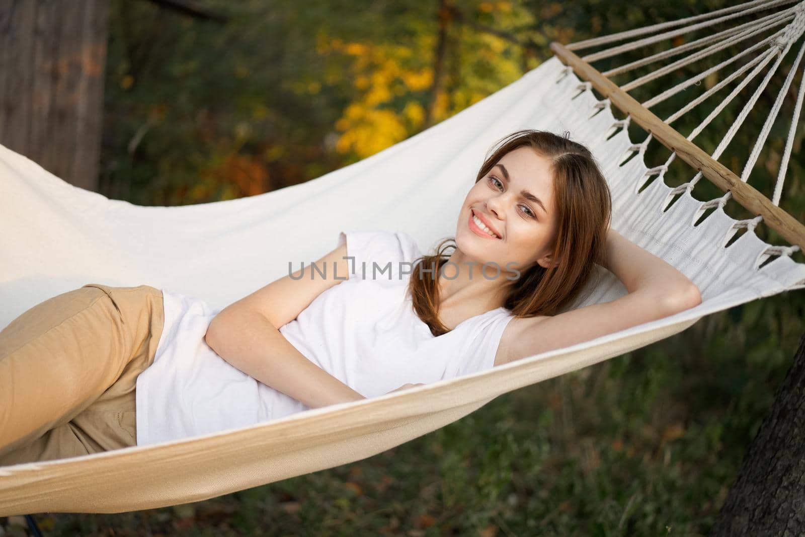 cheerful woman lies in a hammock rest nature fresh air. High quality photo