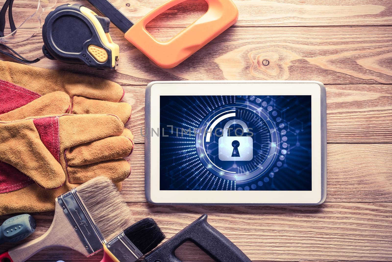 Tablet pc with security concept on screen and industrial tools around