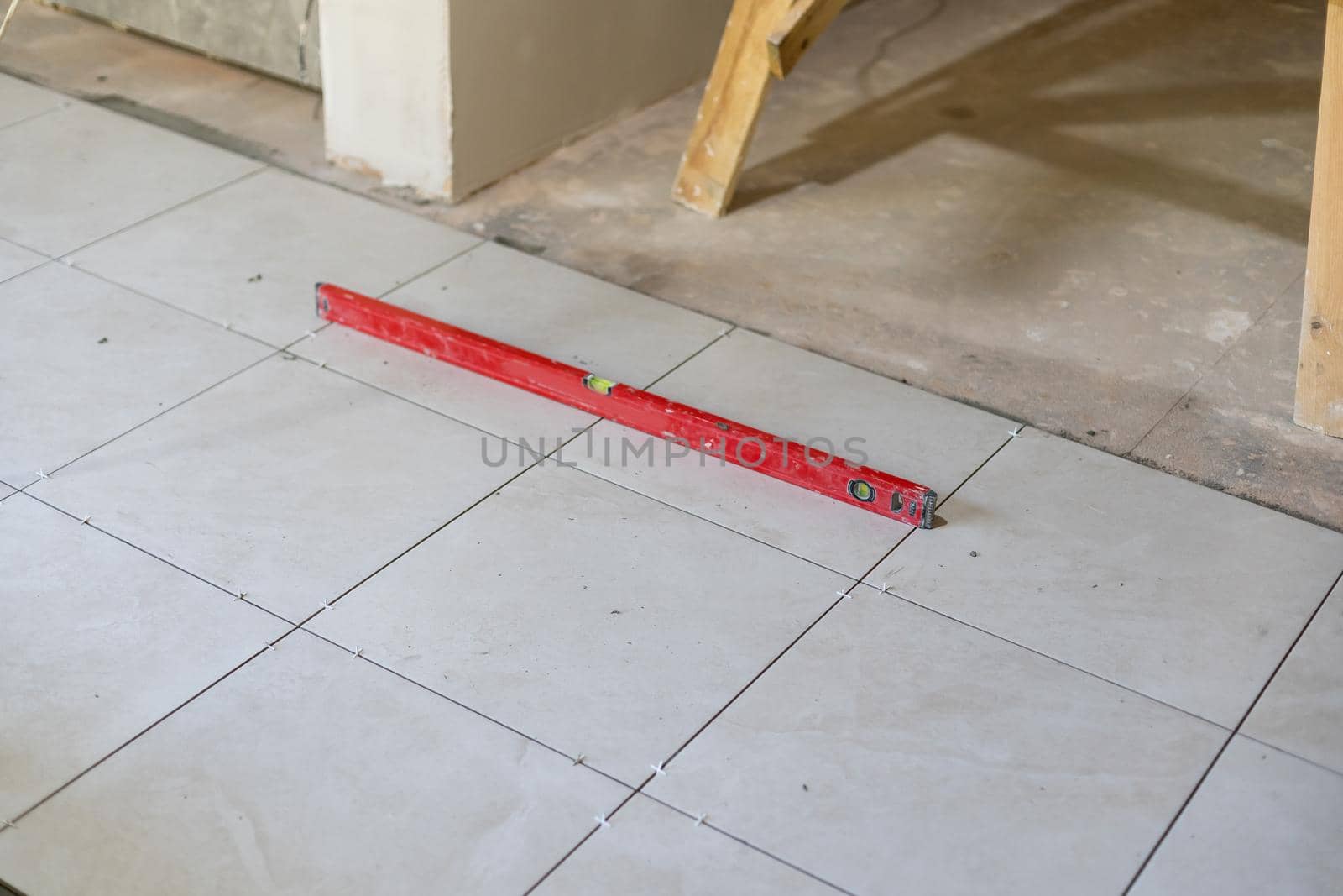 Close-up Installing tiles floor in construction work by Andelov13