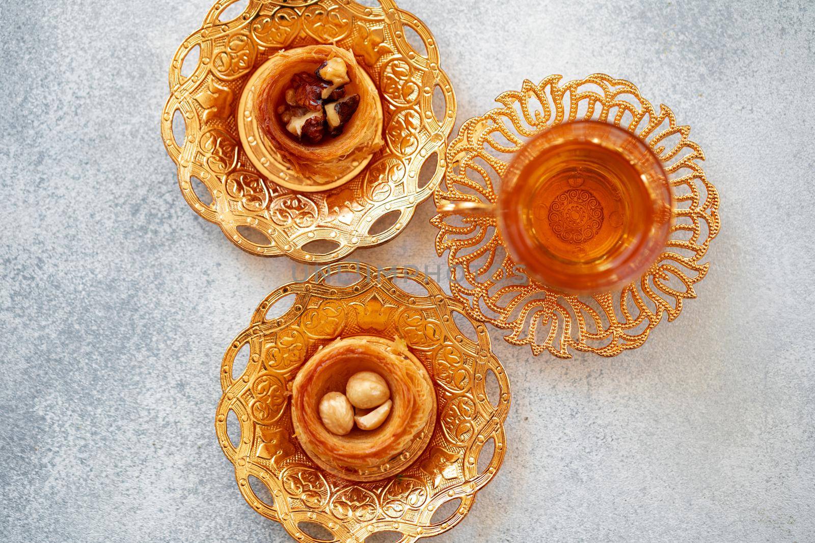 Turkish baklava and Turkish tea in oriental dishes on gray background, close up