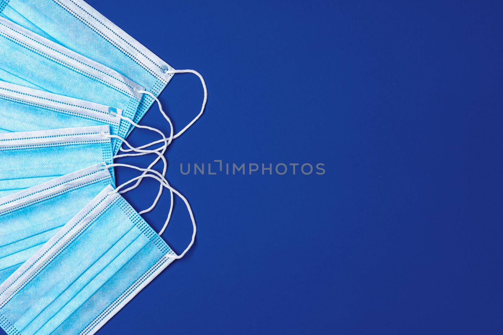 Medical face mask on blue background. Coronavirus covid-19 prevention concept