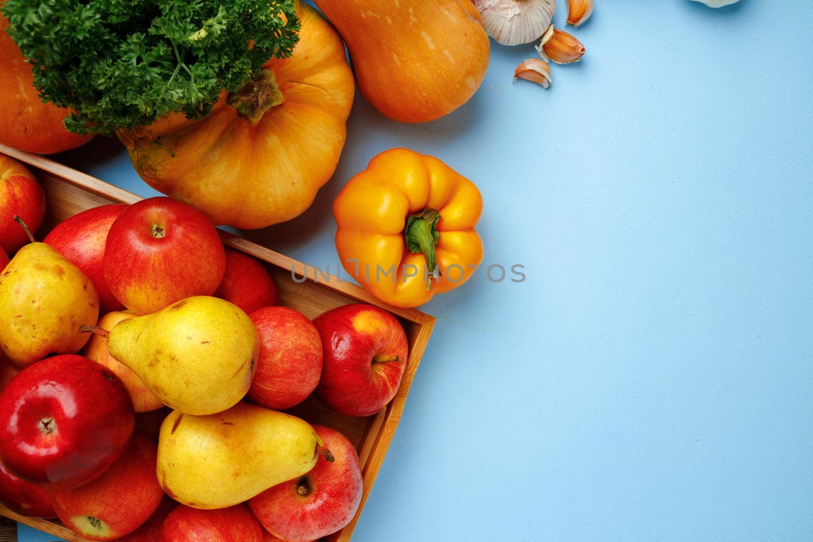 Pumpkins, apples and bell pepper composition on blue background top view