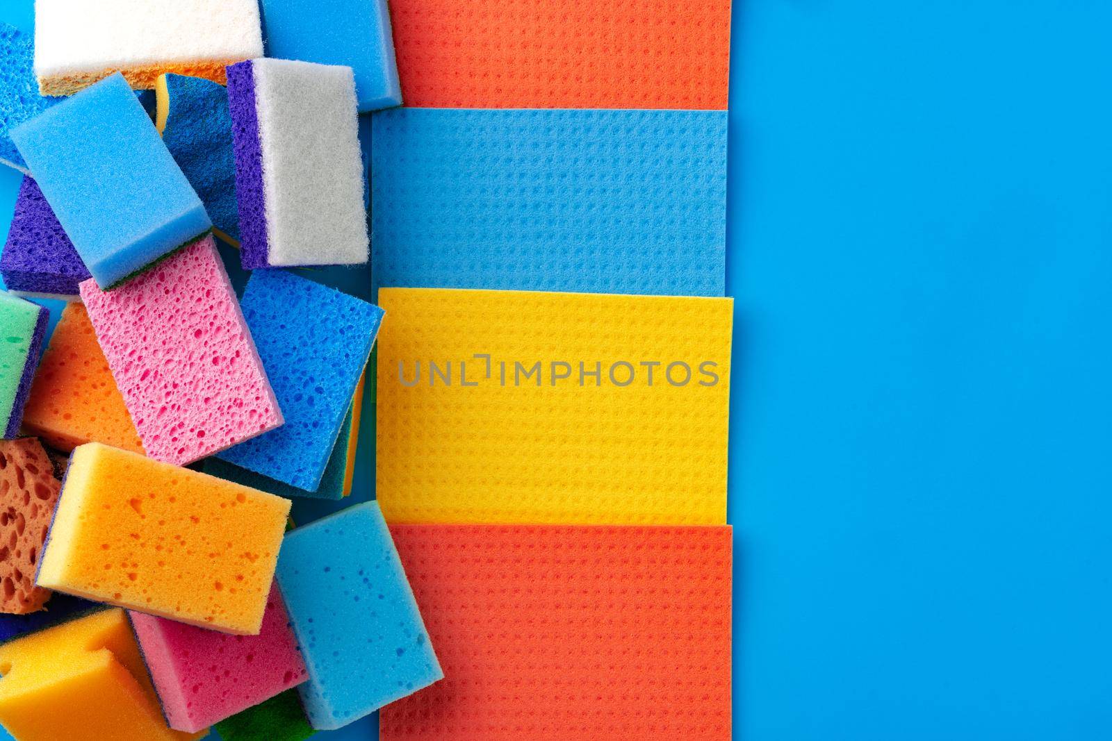 House cleaning supplies on blue color background, top view