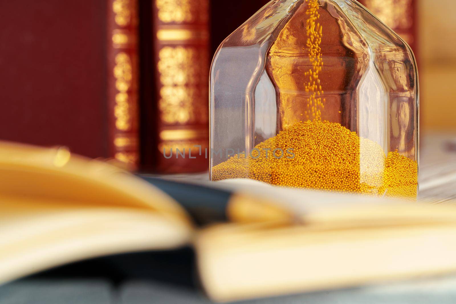 Golden sand hourglass close up on working table. Close up.