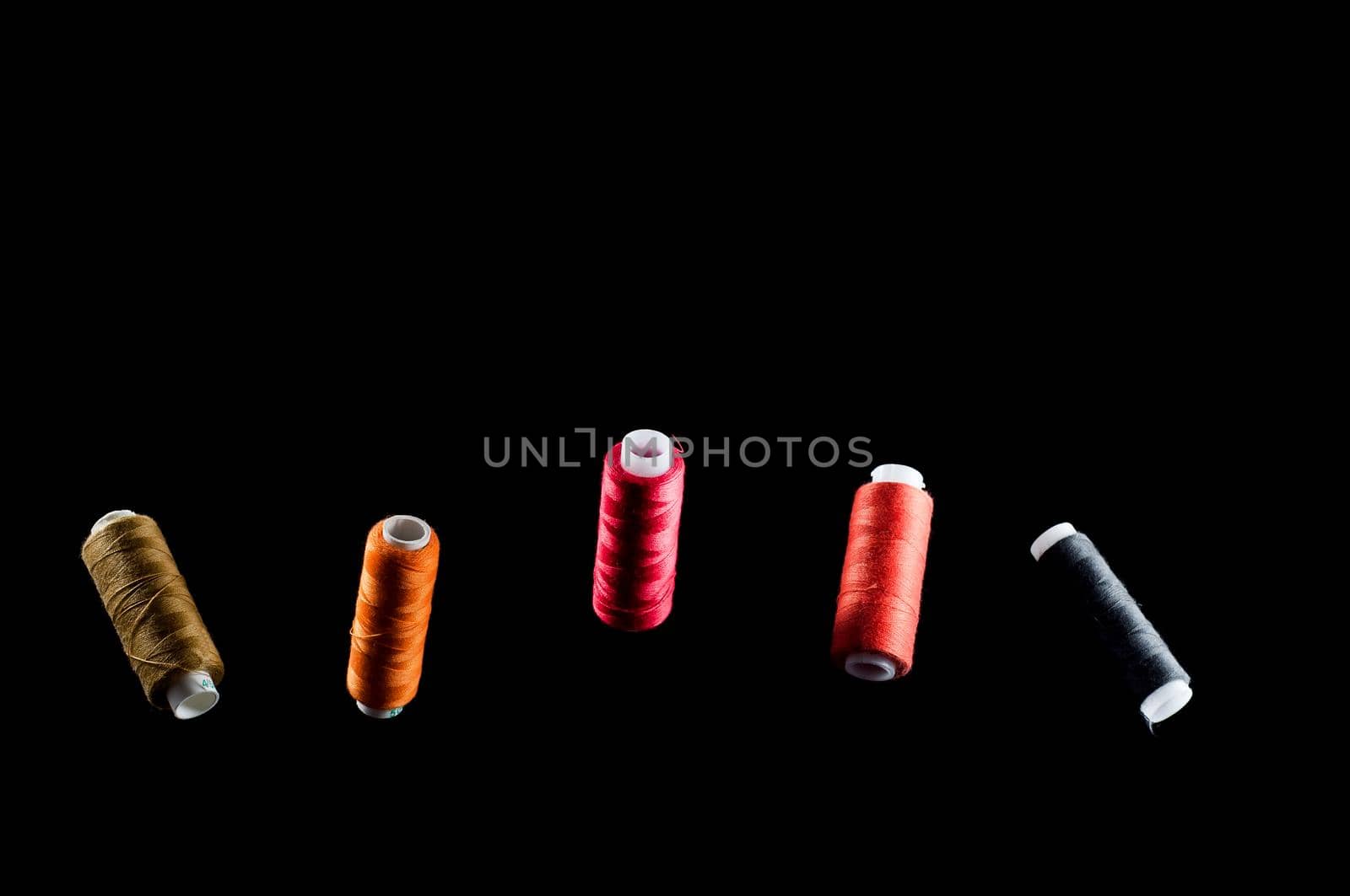 Black, bronze, orange, red and pink threads floating in the air against a black background, isolate by Vladvvv