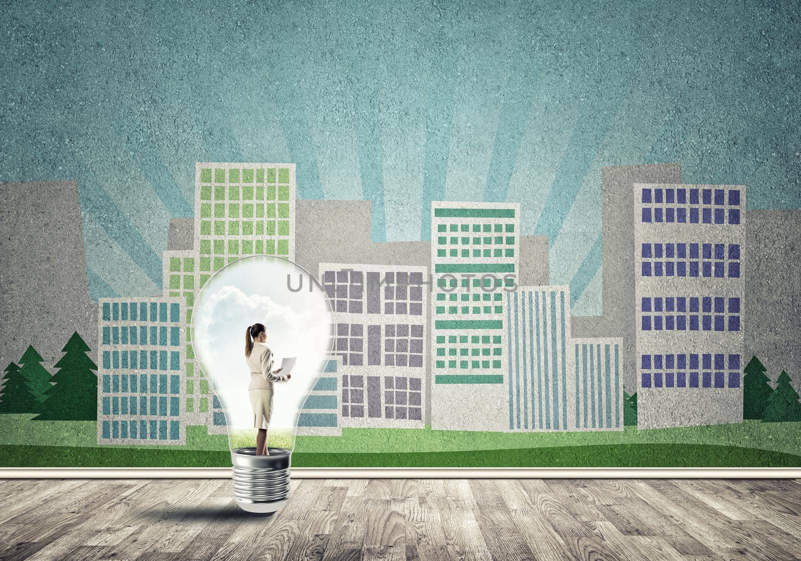 Businesswoman inside light bulb against city drawn concept