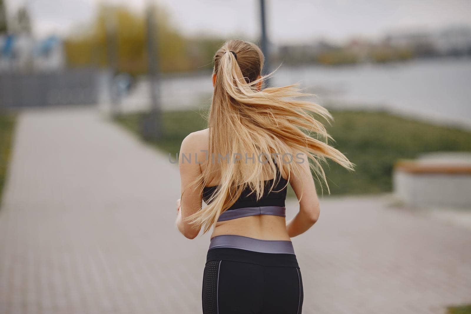 Beautiful girl training. Sports girl in a sportswear. Blonde by the water.