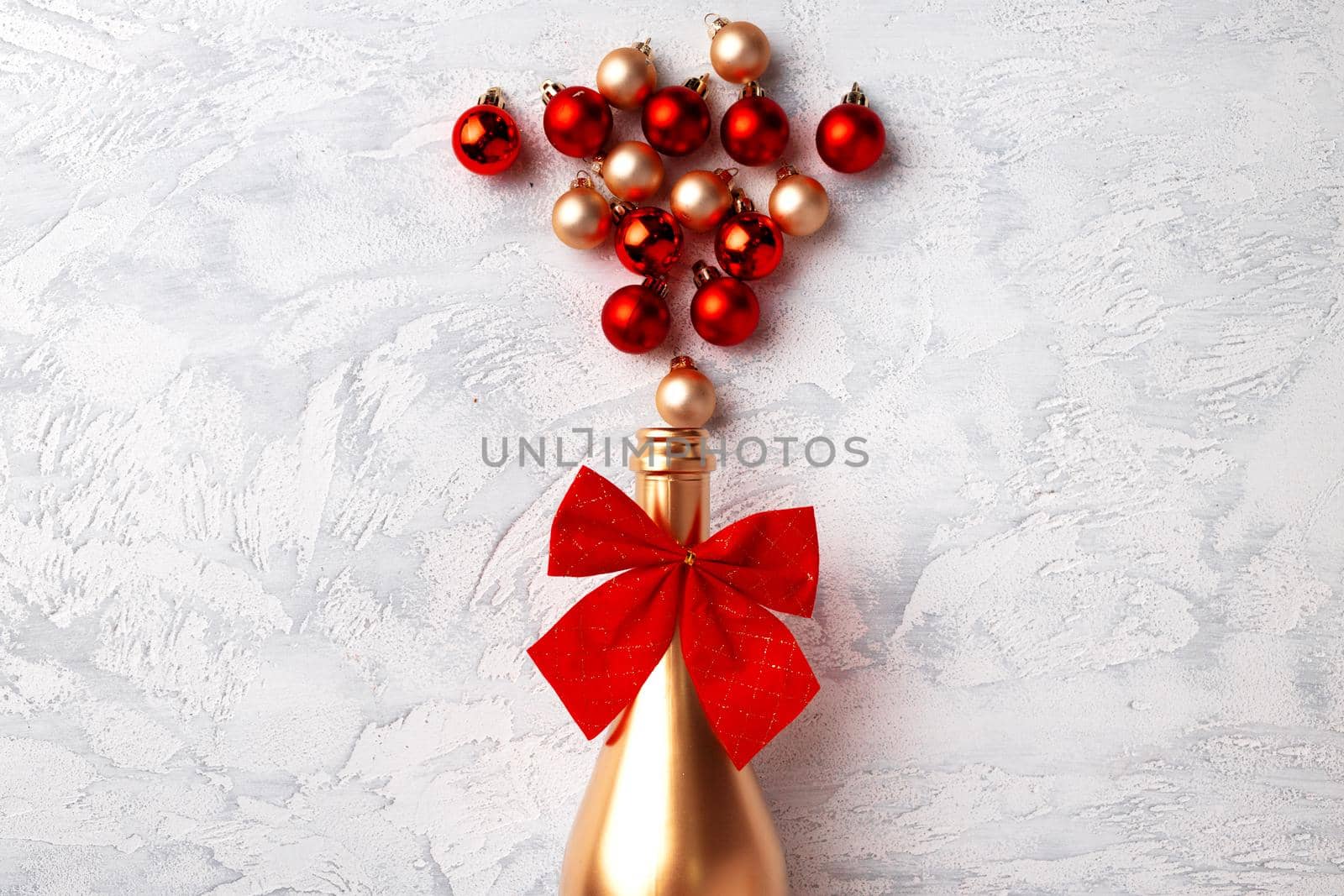 Flat lay composition with gold champagne bottle and Christmas balls top view