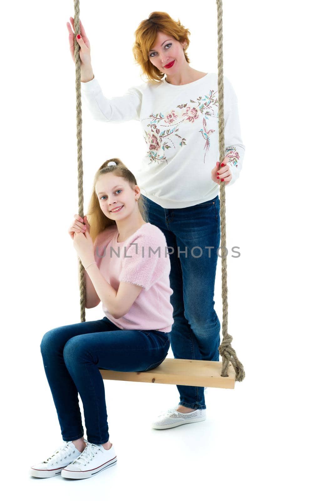 Happy mom and daughter swing on a swing. The concept of family happiness, parenting. Isolated on white background.