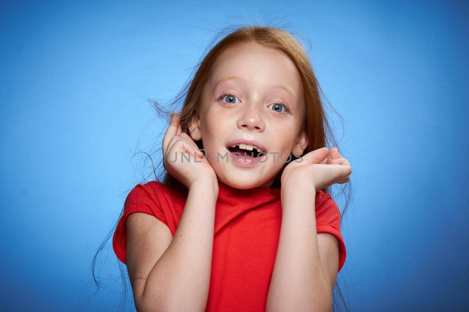 cheerful cute red-haired girl childhood blue background by Vichizh