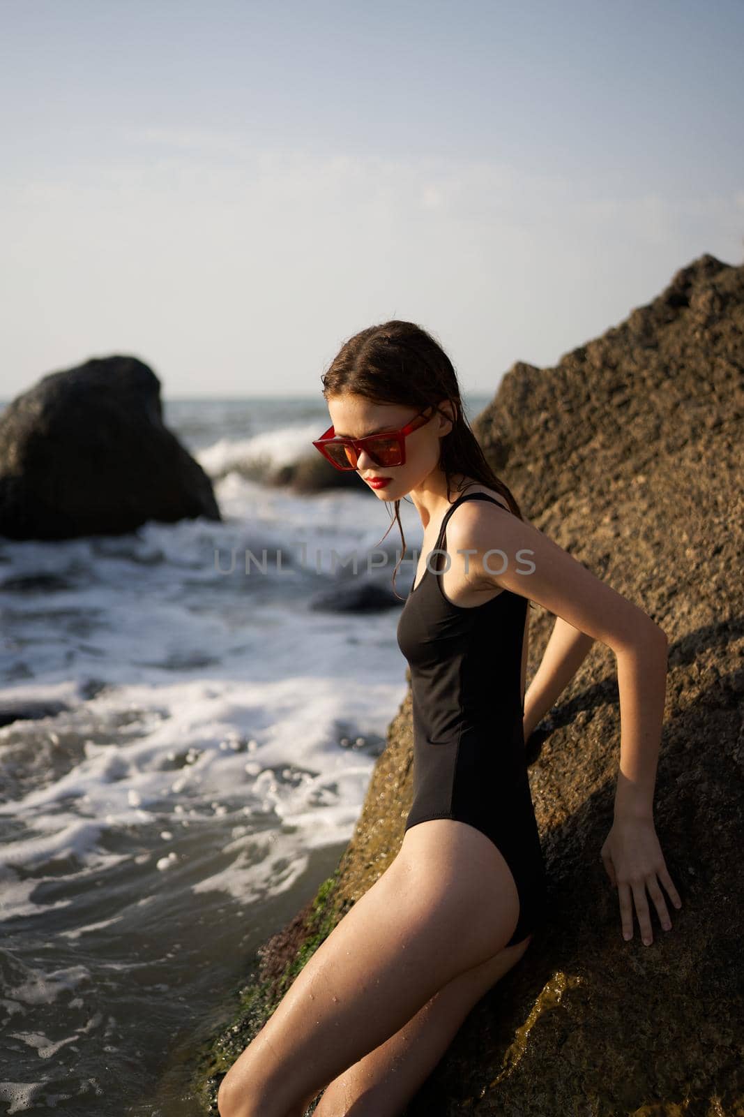 woman in swimsuit sunglasses ocean rocks posing by Vichizh