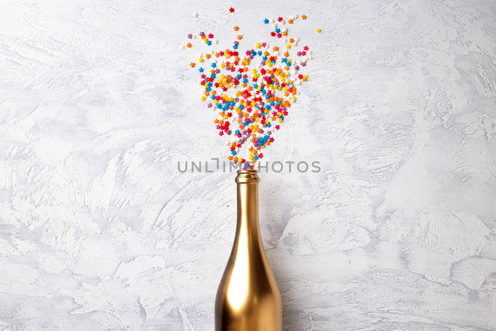 Champagne bottle with confetti flat lay top view, christmas background