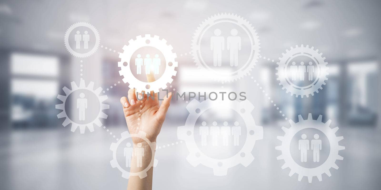 Close of woman hand touching gears on screen with finger and office at background