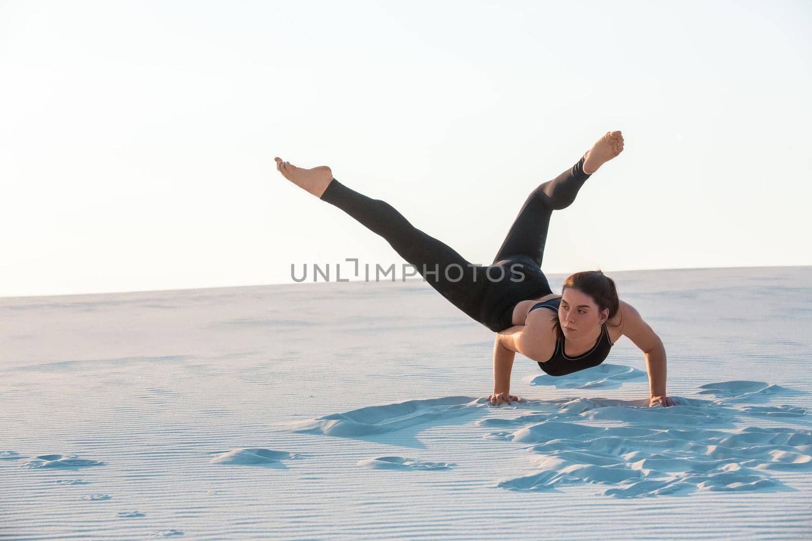 Young professional gymnast woman dance outdoor - sand beach. Fitness, sport, people and lifestyle concept