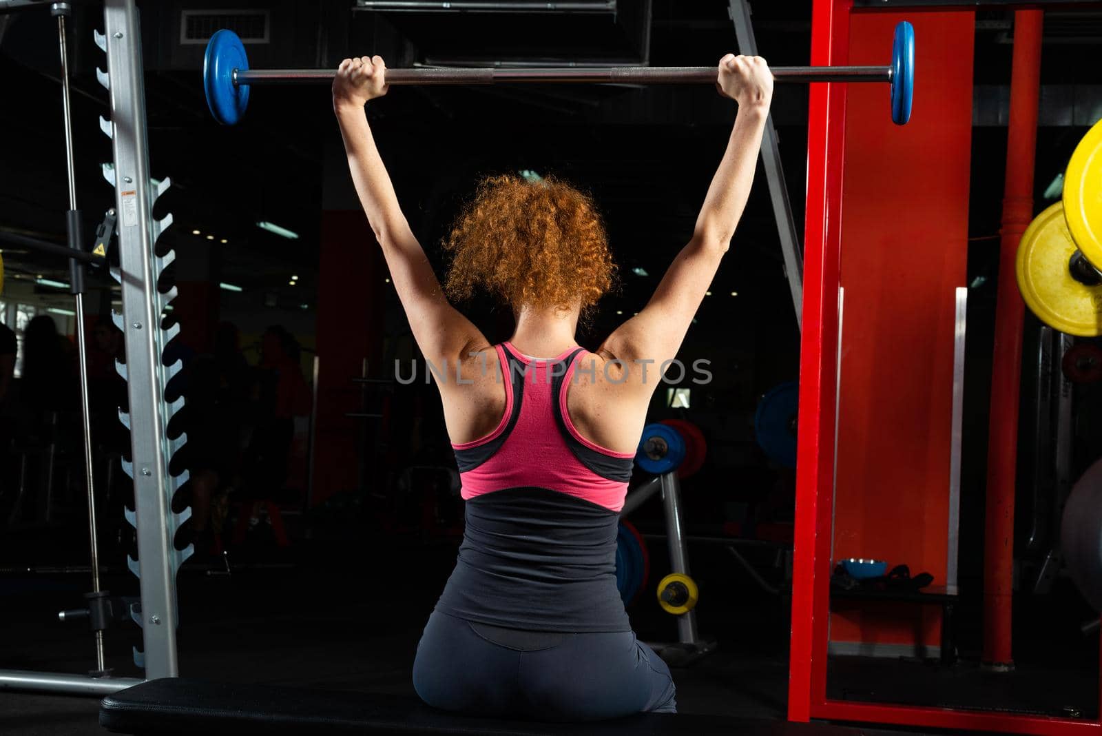 Woman bodybuilder engaged with a barbell in the gym. Healthy lifestyle.