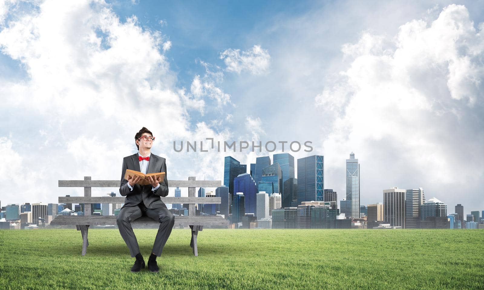 Young student sits on a wooden bench with a book