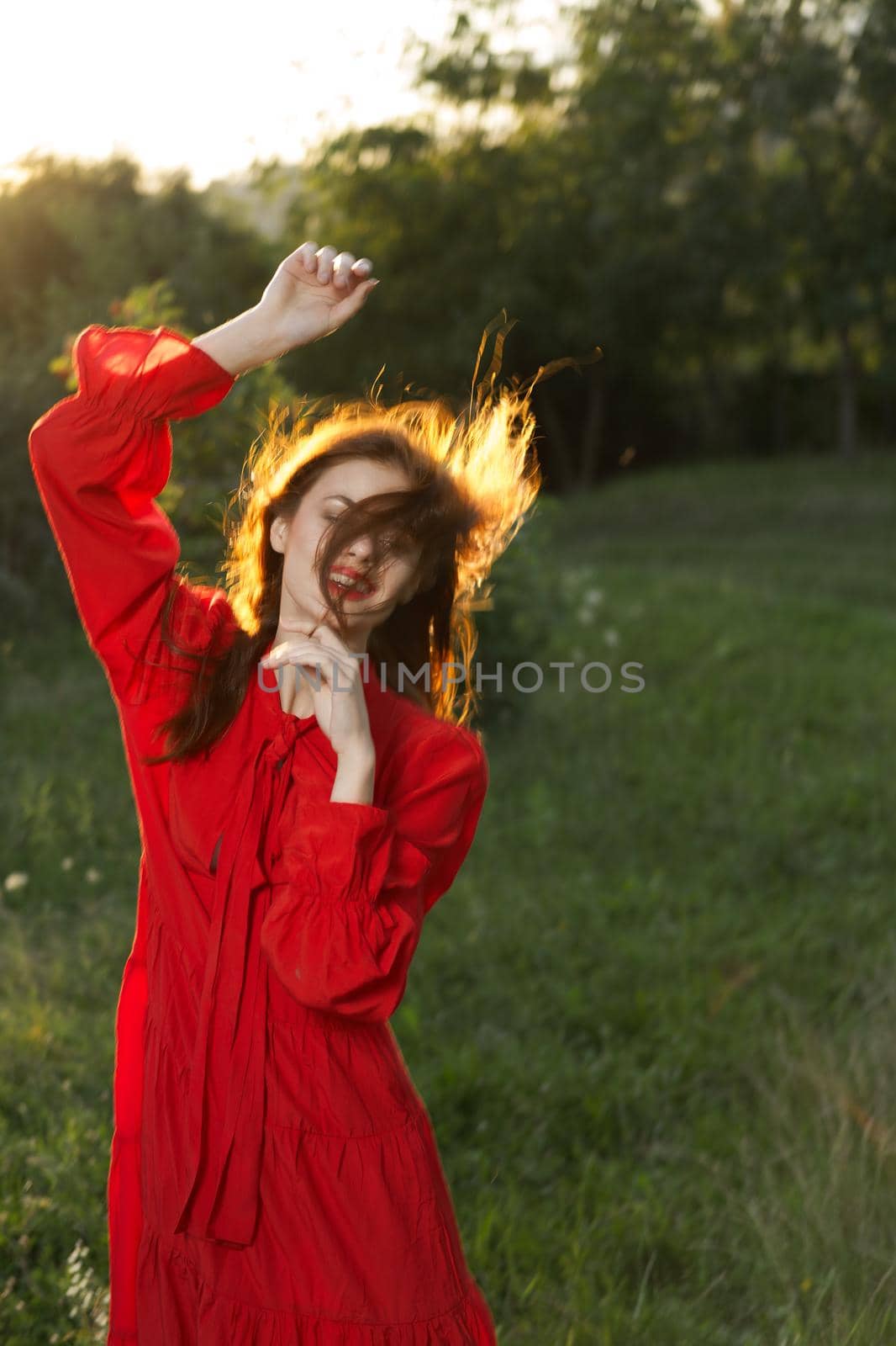 woman in red dress posing nature sun fun. High quality photo