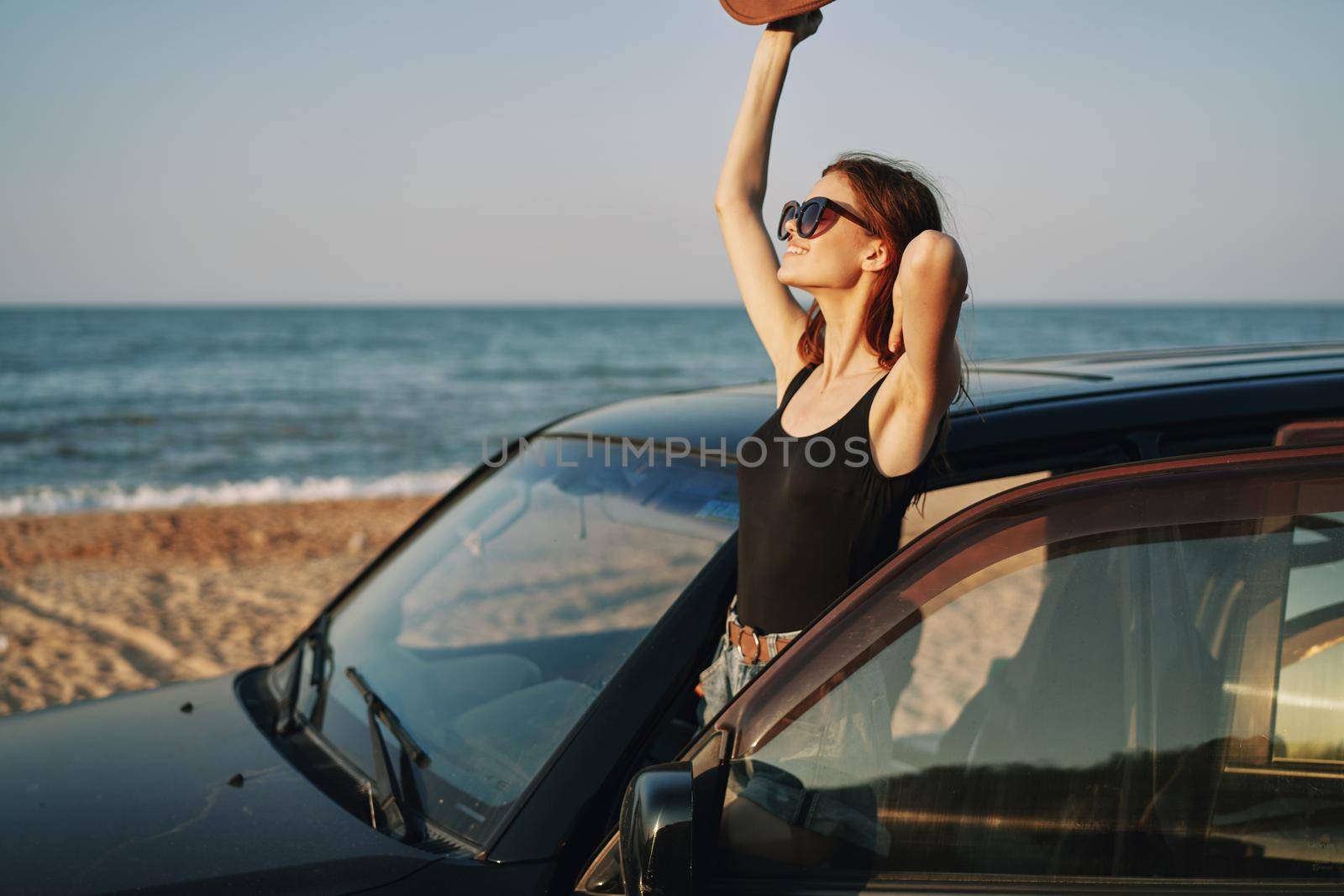 woman on the beach is with a car wearing sunglasses travel. High quality photo