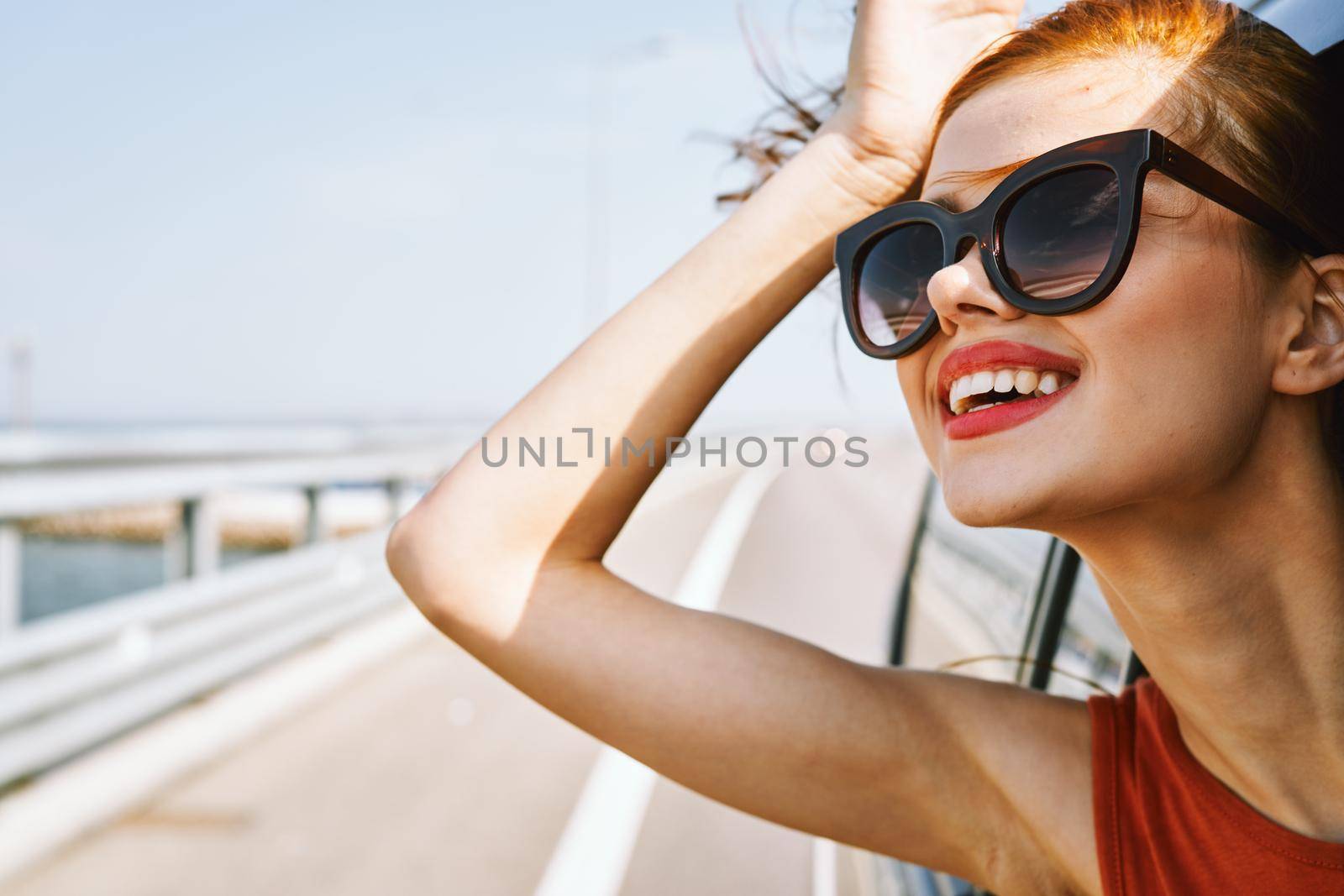 cheerful woman peeking out of the car window trip adventure lifestyle by Vichizh