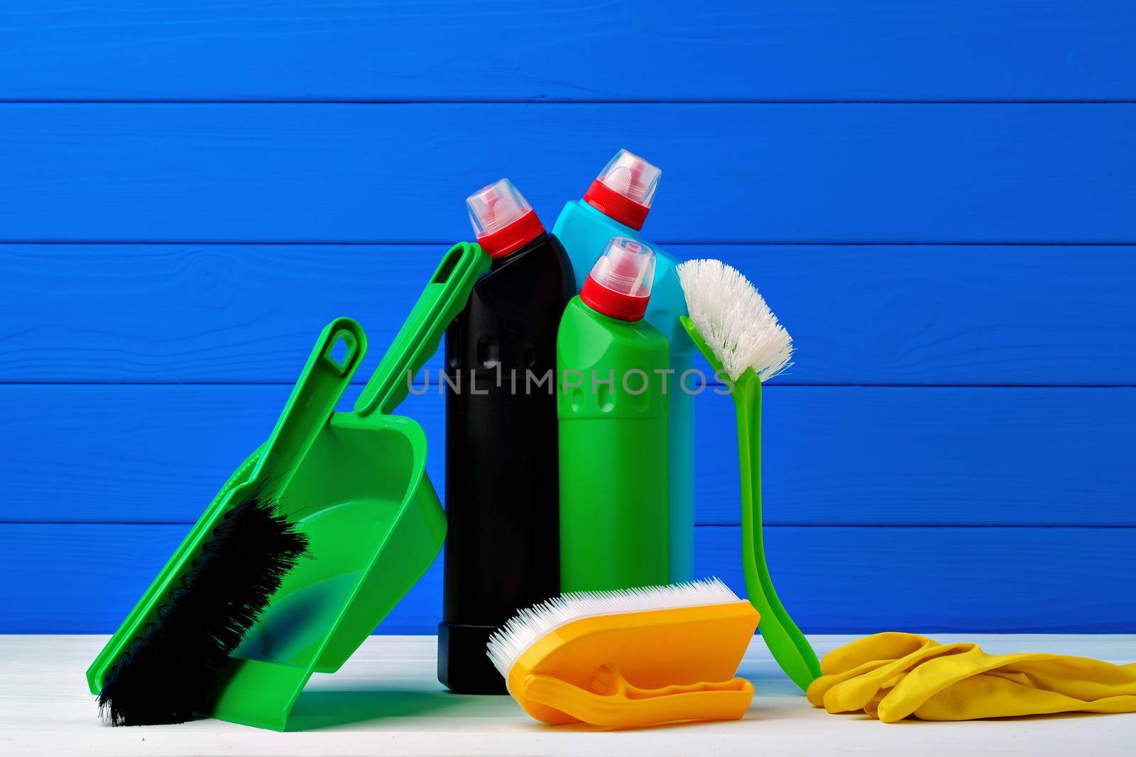 Various cleaning items against blue wooden background, front view