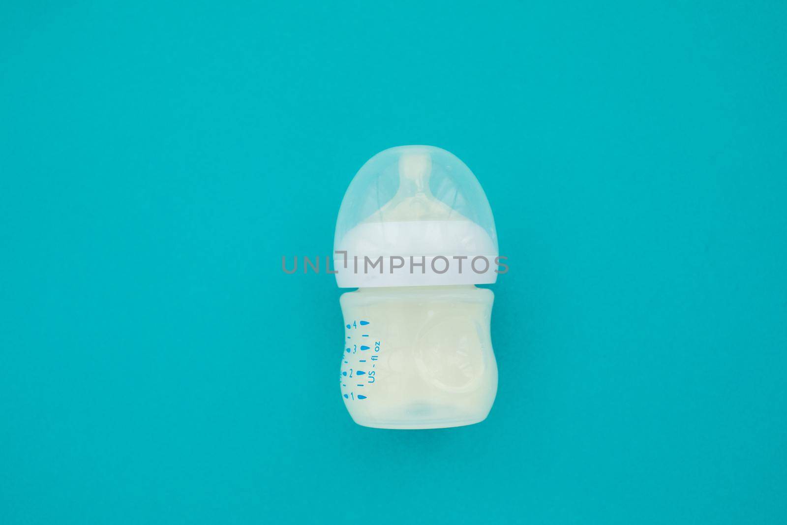 Baby bottle whith mixture milk baby feeding blue background top view