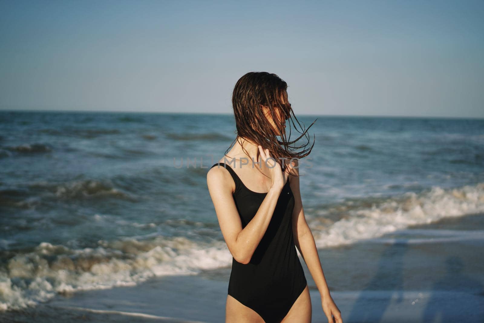 cheerful woman in black swimsuit sunglasses ocean travel. High quality photo