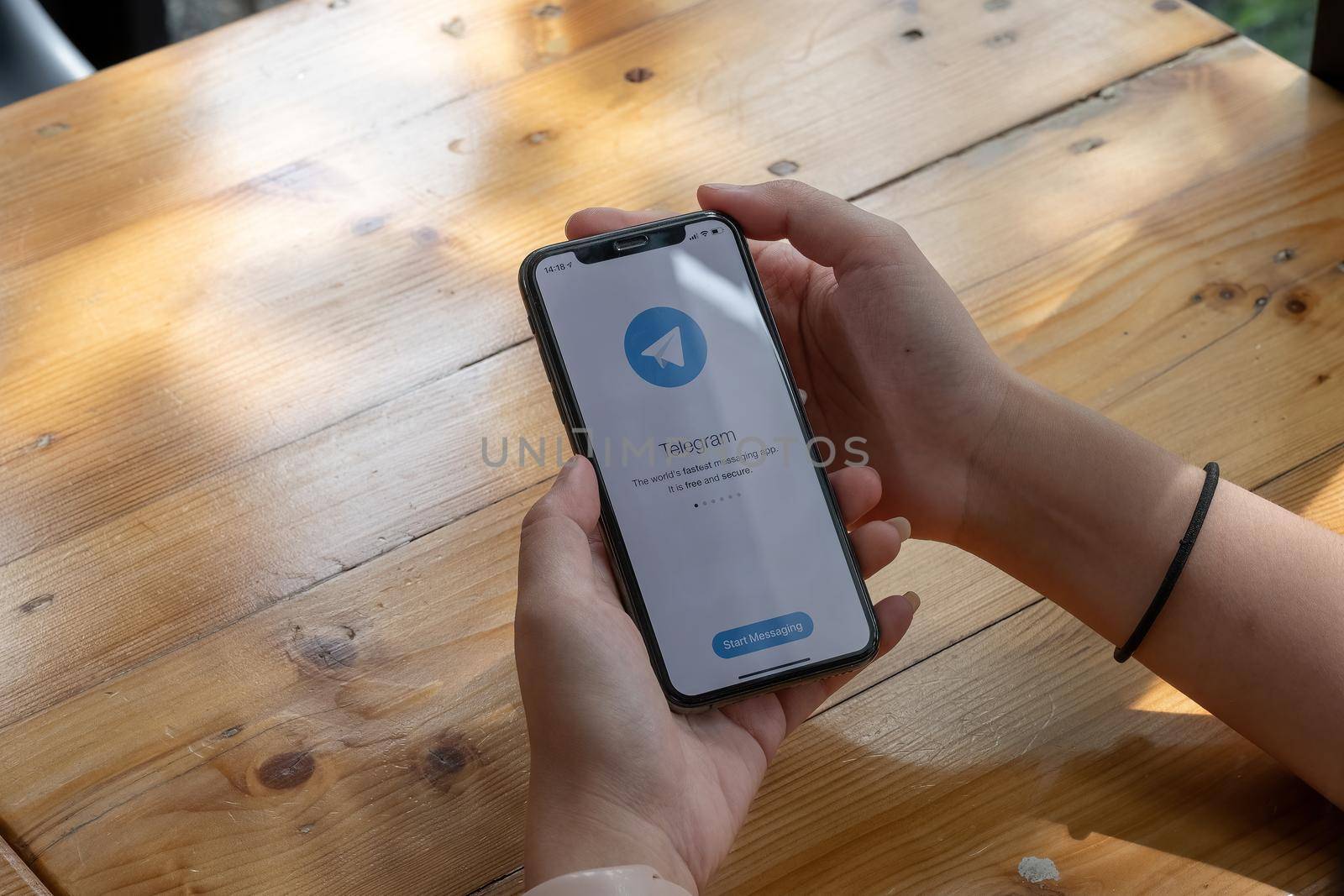 CHIANG MAI, THAILAND, JUL 27, 2021 : Woman hand holding iPhone X with social networking service Telegram on the screen. iPhone 10 was created and developed by the Apple inc.