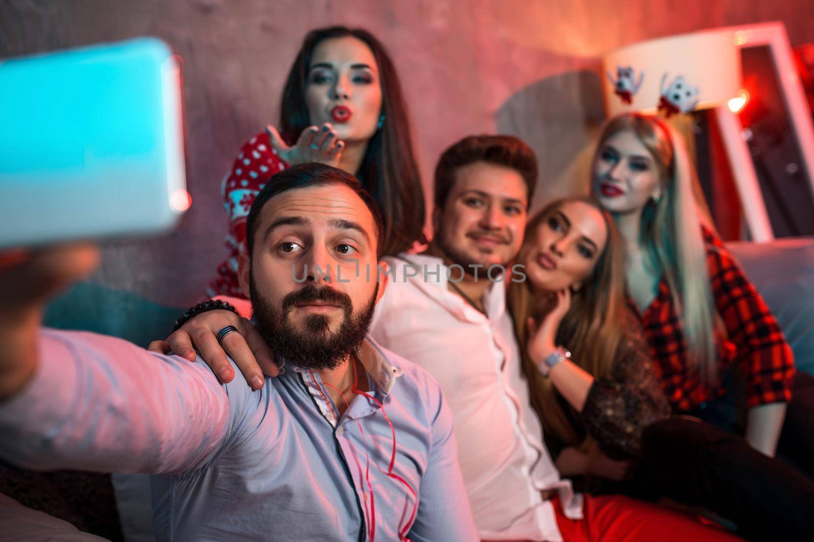 Friends making selfie while celebrating Christmas or New Year eve at home by nazarovsergey