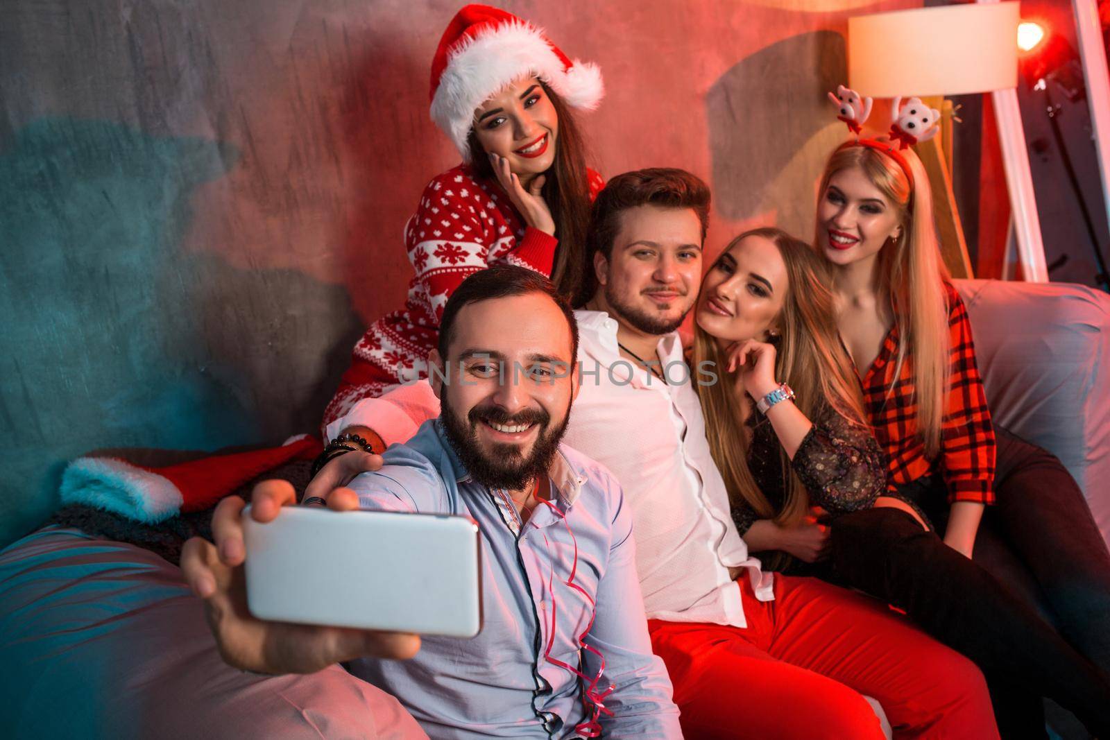 Friends making selfie while celebrating Christmas or New Year eve at home by nazarovsergey