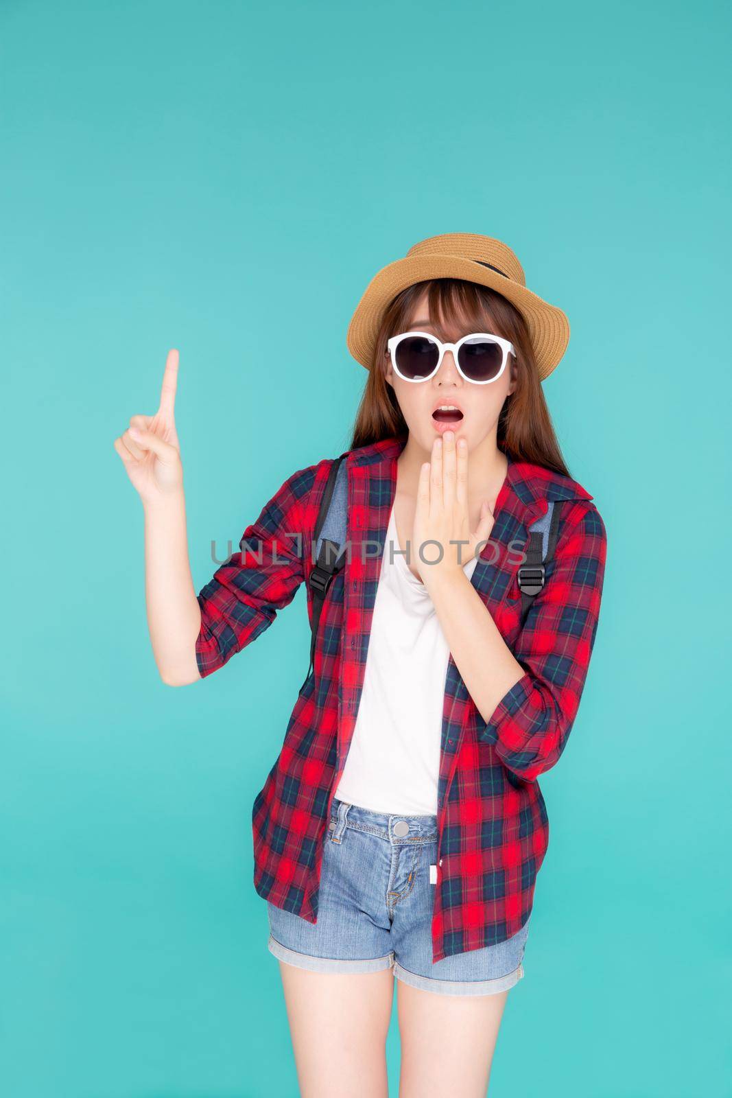 Beautiful portrait young asian woman surprise wearing sunglasses and hat travel summer fashion with tourist isolated on blue background, girl shocked expression and emotion, holiday amazing concept. by nnudoo