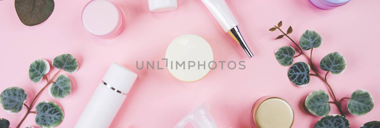 Mockup cosmetic bottle with cream or lotion and leaf isolated on pink background, mock up package for advertising, skincare or cosmetology, top view, flat lay, skin care and treatment with product.