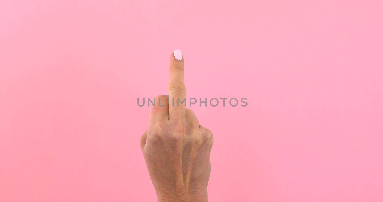 Woman hand gesture meaning in western cultures Fuck you or fuck off isolated pink screen