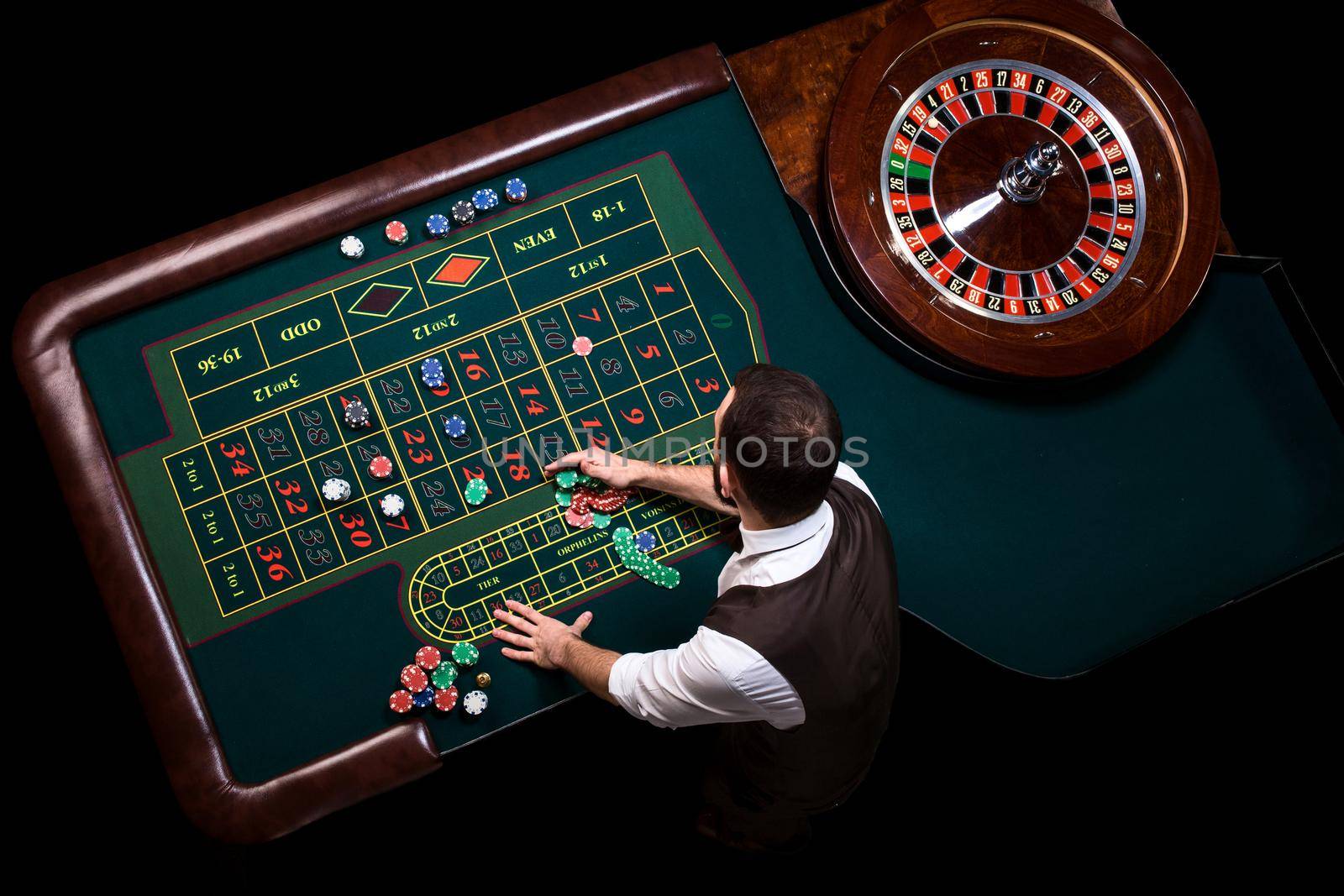 Gambling table in luxury casino. Top view of the casino croupier and the green roulette table. Gambling. Casino. Roulette. Poker.